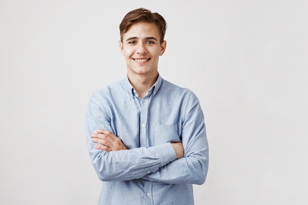 Portrait de beau jeune homme aux bras croisés