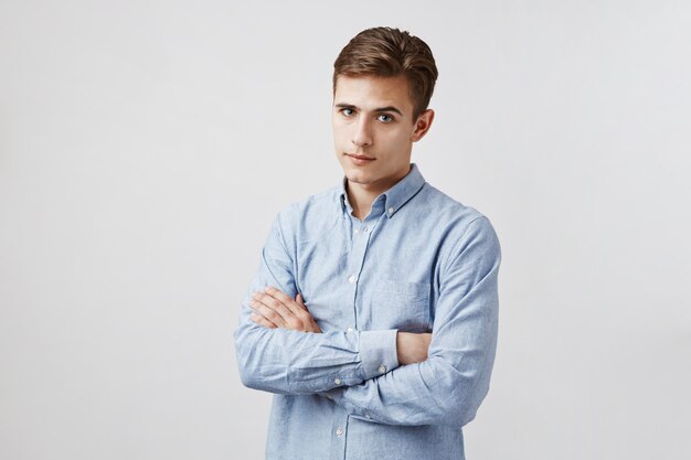 Portrait de beau jeune homme aux bras croisés