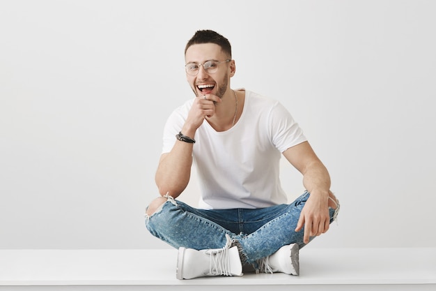 Portrait de beau jeune homme avec des lunettes posant