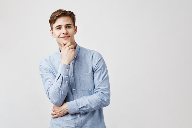 Portrait de beau jeune homme avec la main sur le menton