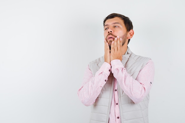 Portrait De Beau Jeune Homme Avec Les Mains Près De La Bouche En Chemise, Gilet Et à La Vue De Face Confuse