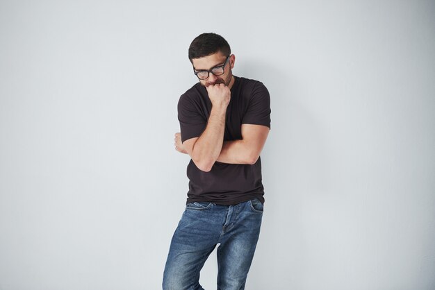 Portrait d'un beau jeune homme pensant à quelque chose, isolé sur blanc