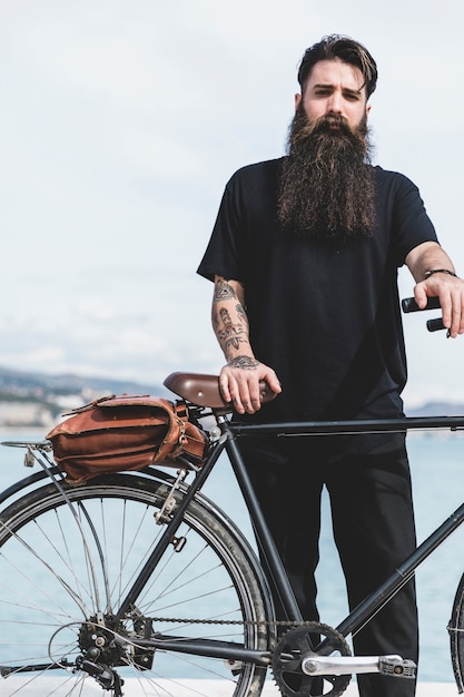 Portrait d&#39;un beau jeune homme avec sa bicyclette