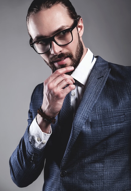 Portrait de beau mannequin d'affaires vêtu d'un élégant costume bleu avec des lunettes