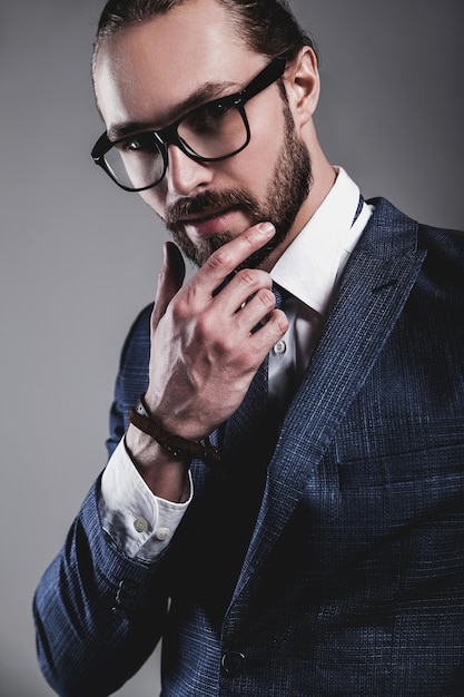 Portrait de beau mannequin d'affaires vêtu d'un élégant costume bleu avec des lunettes