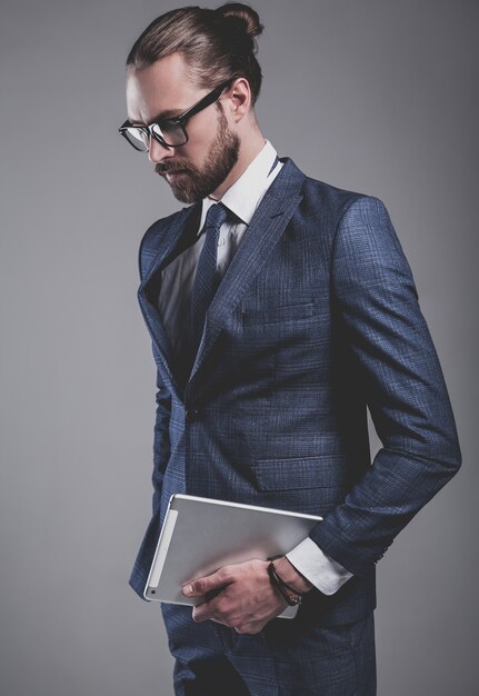 Portrait de beau mannequin d'affaires vêtu d'un élégant costume bleu avec des lunettes