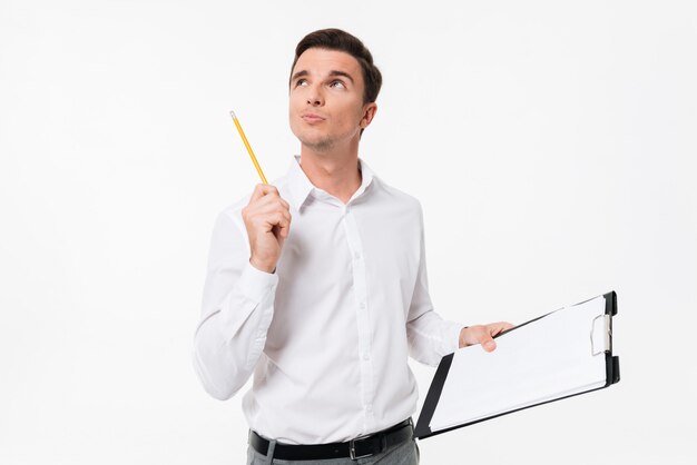 Portrait d'un beau mec songeur en chemise blanche