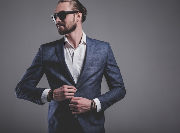 portrait, de, beau, mode, élégant, hipster, homme affaires, modèle, habillé, dans, élégant, costume bleu, dans, lunettes soleil, poser, sur, gris