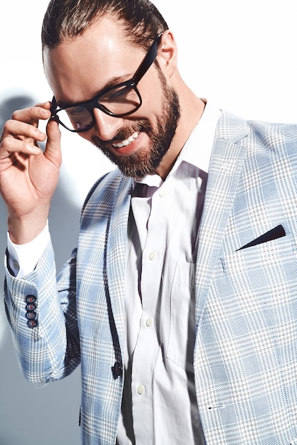 portrait de beau mode élégant hipster homme d'affaires modèle habillé en élégant costume bleu clair dans des verres sur blanc.