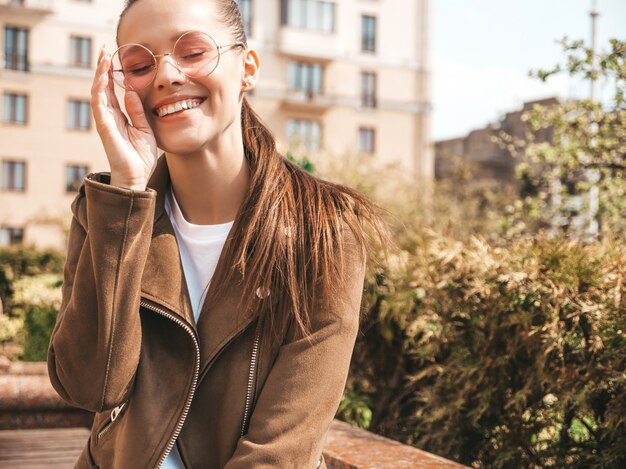 Portrait de beau modèle brune souriante vêtue de vêtements de veste hipster d'été