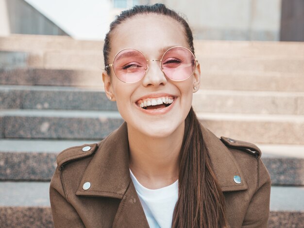 Portrait de beau modèle brune souriante vêtue de vêtements de veste hipster d'été