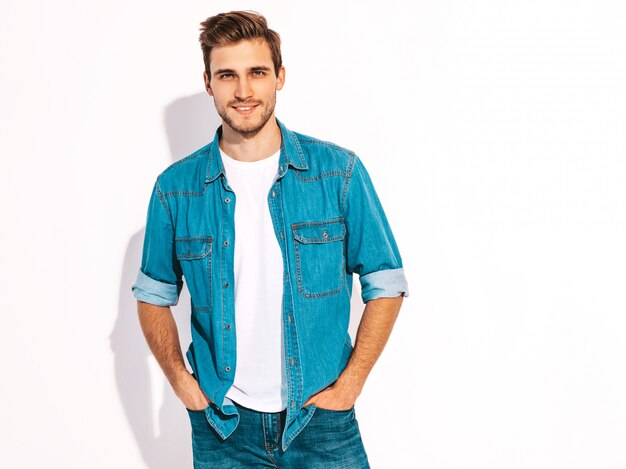 Portrait de beau modèle élégant jeune homme souriant vêtu de vêtements jeans. Homme de mode