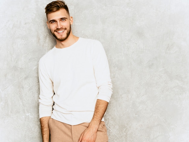 Portrait de beau modèle d'homme d'affaires souriant hipster portant des vêtements décontractés d'été blanc.