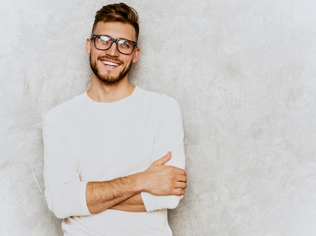 Portrait de beau modèle d'homme d'affaires souriant hipster portant des vêtements décontractés d'été blanc.