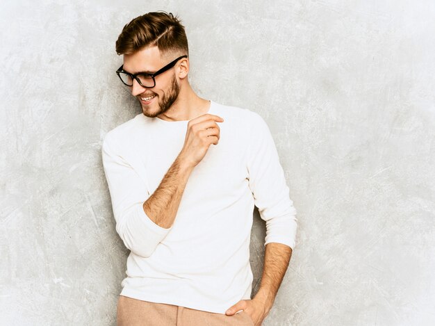 Portrait de beau modèle d'homme d'affaires souriant hipster portant des vêtements décontractés d'été blanc.