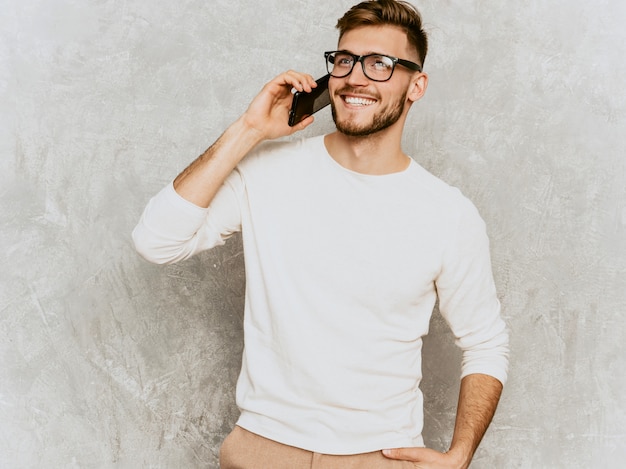 Portrait de beau modèle d'homme d'affaires souriant hipster portant des vêtements décontractés d'été blanc.