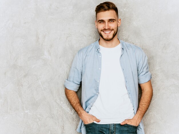 Portrait de beau modèle jeune homme souriant portant des vêtements de chemise décontractée. Homme élégant de mode posant