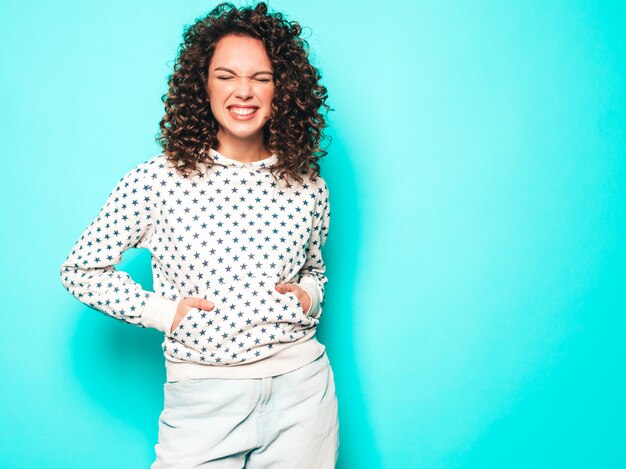 Portrait de beau modèle souriant avec coiffure afro curls vêtu de vêtements d'été hipster.Tendance femme drôle et positive en sweat à capuche blanc