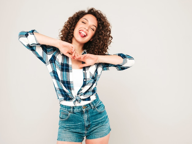 Portrait, de, beau, sourire, modèle, à, afro, boucles, coiffure, habillé, dans, été, hipster, vêtements., Sexy, insouciant, girl, poser, dans, studio, sur, gris, arrière-plan.