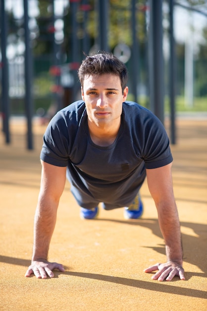 Portrait de beau sportif le jour de l'été. Homme en vêtements sportifs regardant la caméra. Sport, notion de portrait