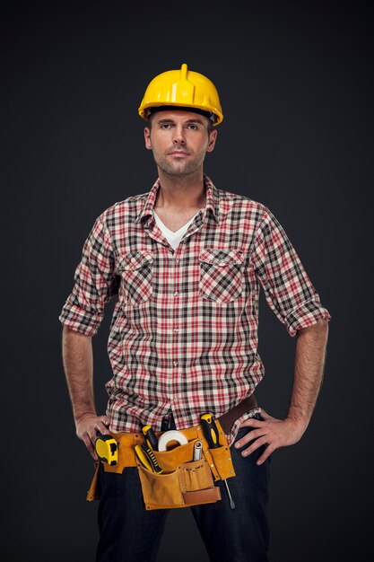 Portrait de beau travailleur manuel avec ceinture à outils
