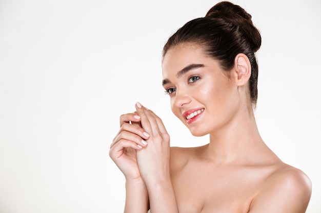 Portrait de beauté de l'adorable femme à moitié nue avec une peau parfaite posant avec les mains ensemble