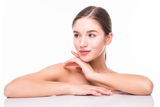 Portrait de beauté d'une jeune femme à moitié nue attrayante avec une peau parfaite posant et en regardant loin sur le mur blanc