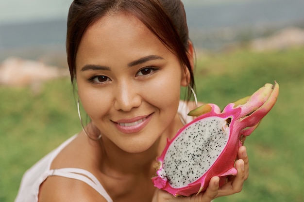 Portrait de beauté de jolie jeune femme asiatique tenant fruit du dragon pitaya