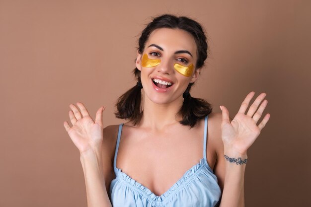 Portrait de beauté proche d'une femme avec une peau parfaite et des taches dorées de maquillage naturel sous les yeux pour hydrater la peau et soulager les poches du visage