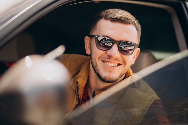 Portrait de bel homme assis dans la voiture