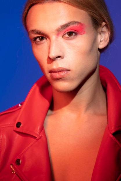 Portrait d'un bel homme aux longs cheveux blonds portant une veste rouge