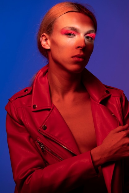 Portrait d'un bel homme aux longs cheveux blonds portant une veste rouge