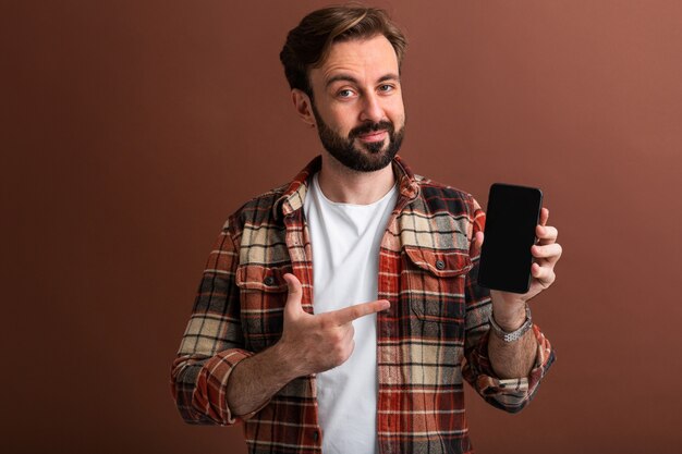 Portrait de bel homme barbu élégant sur brun