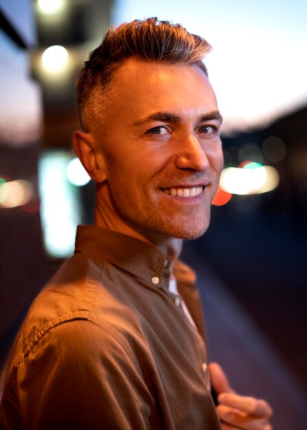 Portrait de bel homme la nuit dans les lumières de la ville