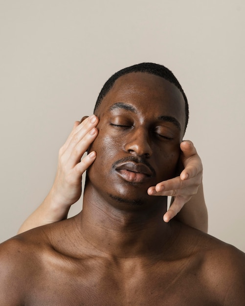 Portrait de bel homme posant avec les mains sur son visage