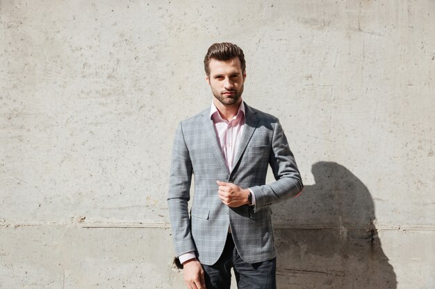 Portrait d'un bel homme sérieux dans une veste debout