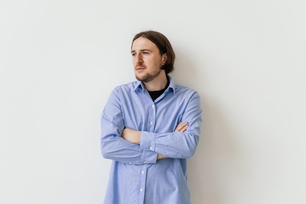 Portrait d'un bel homme souriant debout avec les bras croisés isolé sur fond blanc