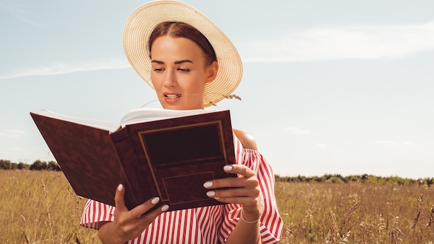 Photo gratuite portrait d'une belle dame. lit un livre sur le terrain. se préparer à l'entrée à l'université.