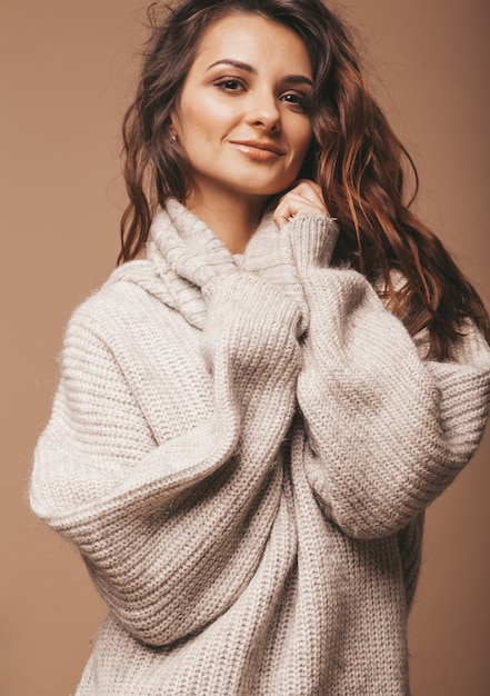 portrait de belle douce femme brune souriante mignonne. Fille en pull gris décontracté. Modèle, poser, studio