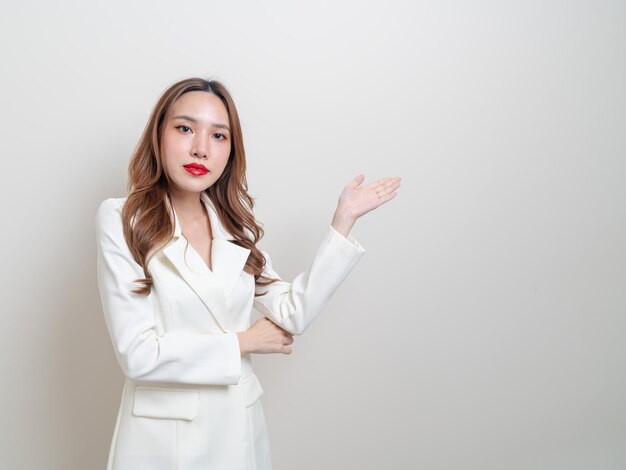 Portrait belle femme d'affaires asiatique avec la main présentant ou pointant sur fond blanc