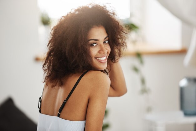 Portrait de la belle femme africaine souriante. Arrière-plan de la chambre.