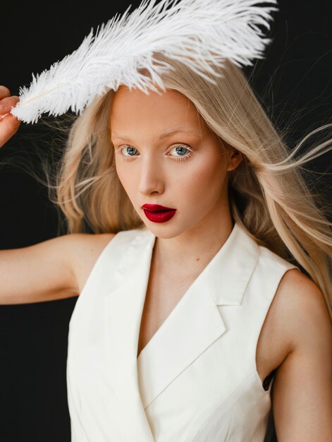 Portrait de belle femme albinos avec plume blanche