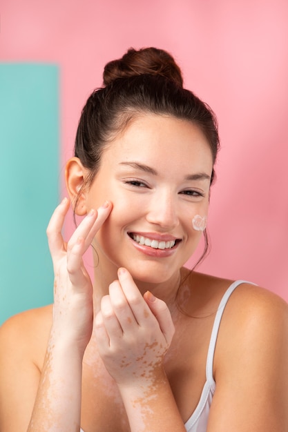 Portrait d'une belle femme appliquant une crème hydratante