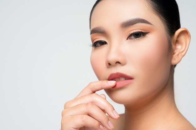 Portrait d'une belle femme asiatique aux cheveux noirs et aux lèvres roses