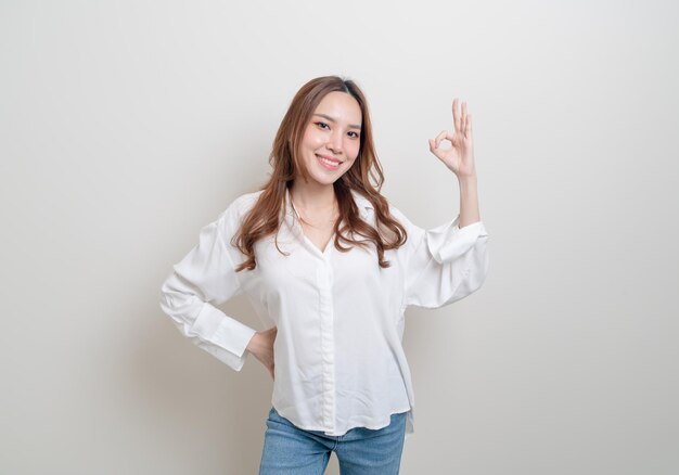 Portrait belle femme asiatique avec hand show ok ou d'accord signe de la main sur fond blanc