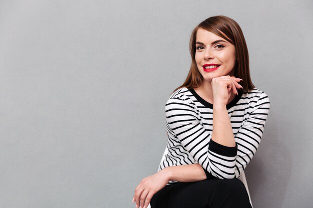 Portrait d'une belle femme assise sur une chaise