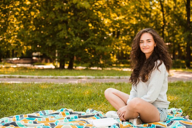 Portrait d&#39;une belle femme assise sur une couverture