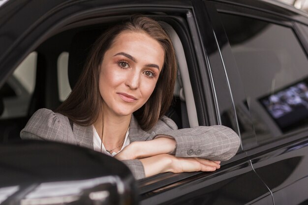 Portrait de la belle femme assise dans une voiture