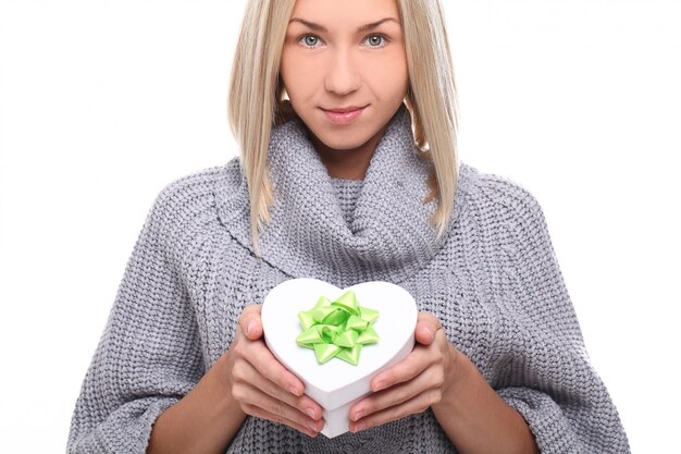 Portrait de la belle femme blonde avec boîte-cadeau en forme de coeur