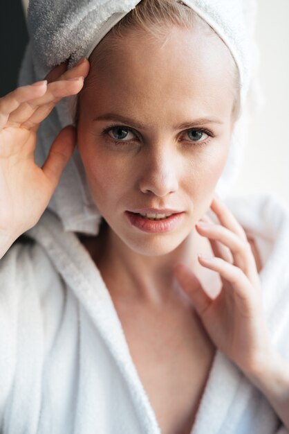 Portrait de la belle femme blonde à la recherche d'appareil photo